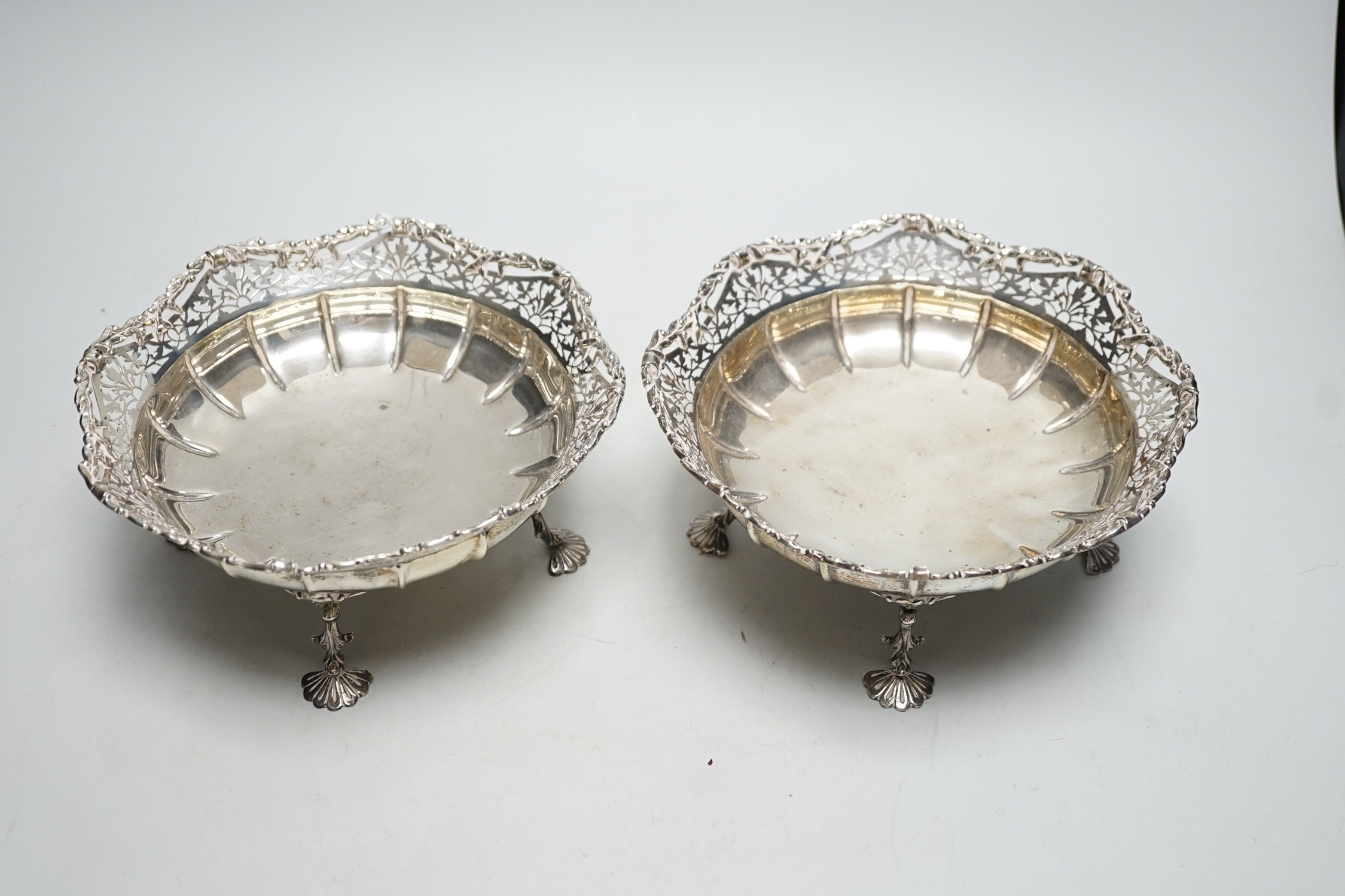 A pair of George VI pierced silver fruit bowls, on quadruped supports, with shell feet, James Ramsay, Birmingham, 1946, diameter 19.2cm, 29.7oz.